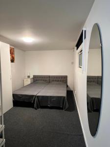 a small room with a bed and a mirror at Mini Hus in Märsta