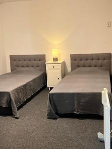 two beds sitting next to each other in a room at Mini Hus in Märsta