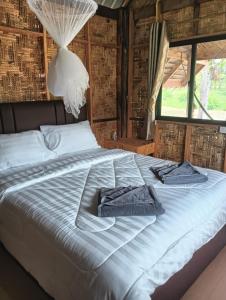 een bed in een kamer met handdoeken bij Bansuan Lanta Maikaew in Koh Lanta +13 foto's
