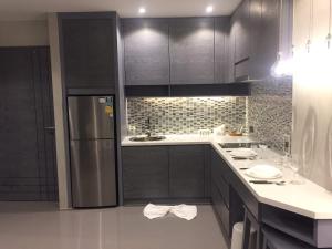 een keuken met zwarte kasten en een roestvrijstalen koelkast bij luxury apartment at Kamala in Kamala Beach