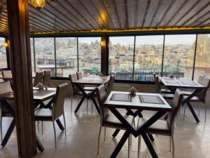 een restaurant met tafels en stoelen en een groot raam bij Alaca Cave Cappadocia in Goreme