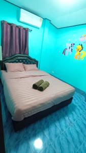 una camera da letto con un letto in una stanza blu di บ้านปรินรดา poolvilla สัตหีบ a Sattahip