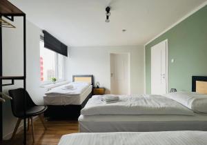 een slaapkamer met twee bedden en een stoel erin bij Cozy, central, fully equipped in Essen in Essen +8 foto's