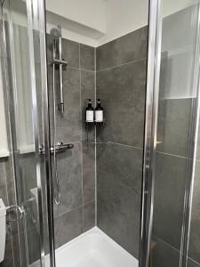 een badkamer met een douche en 3 flessen wijn bij Cozy, central, fully equipped in Essen in Essen