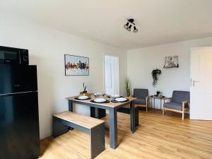 een woonkamer met een tafel en een zwarte koelkast bij Cozy, central, fully equipped in Essen in Essen