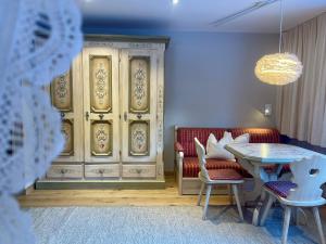 een kamer met een tafel en stoelen en een kast bij Heutaler Hof - Hotel im Naturidyll in Unken +70 foto's