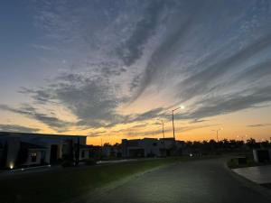 an empty street with a cloudy sky at sunset at Hermosa casa súper equipada in Miramar