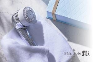 een zilveren sleutel die naast een blauwe doos ligt bij Hotel Monterey La Soeur Naha in Naha +3 foto's