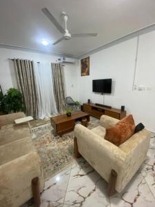 ein Wohnzimmer mit zwei Sofas und einem Flachbildfernseher in der Unterkunft Casa Bellah Sunrise in Watamu