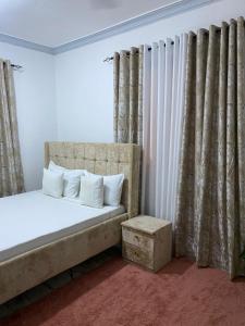 Schlafzimmer mit einem Bett mit weißen Kissen und Vorhängen in der Unterkunft Casa Bellah Sunrise in Watamu + 47 Fotos