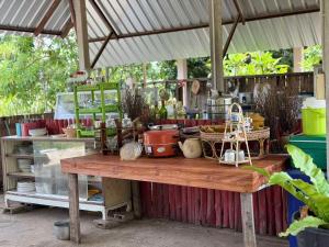a table with a bunch of items on it at Baan Suan Chay Nam Homestay Amphawa in Amphawa