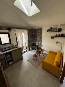 een woonkamer met een gele bank en een tafel bij Sicilia con Terraza y chimenea in Santeagueda