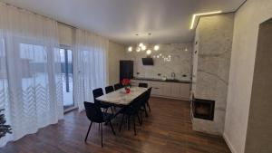 a kitchen and dining room with a table and chairs at Корчин Гарден Шале in Korchin +29 photos