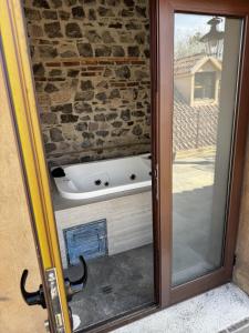 een badkuip die zich in een glazen deur bevindt bij Sicilia con Terraza y chimenea in Santeagueda +58 foto's