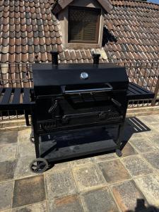 een zwarte barbecuegrill op een betegeld terras bij Sicilia con Terraza y chimenea in Santeagueda
