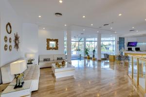 a living room with white walls and wooden floors at Cala Millor Garden Hotel - Adults Only in Cala Millor