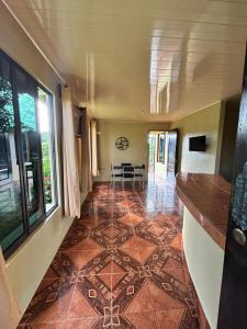 een lege hal met een tegelvloer en ramen bij Cabaña La Conquista in Sarapiquí