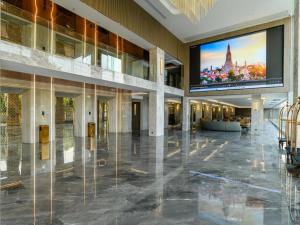 een lege lobby met een groot scherm in een gebouw bij HuiKe MARITZTLE HOTEL in Ban Bang Toei (1)