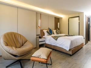 une chambre d'hôtel avec un lit et une chaise dans l'établissement 酒店MARQUIS HOTEl, à Ban Bang Toei (1) 35 autres photos