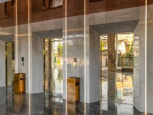 een lobby met twee glazen deuren en twee prullenbakken bij HuiKe MARITZTLE HOTEL in Ban Bang Toei (1) +32 foto's
