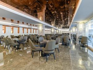 un restaurant avec des tables et des chaises dans une salle dans l'établissement 酒店MARQUIS HOTEl, à Ban Bang Toei (1)