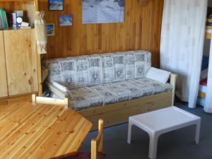 a living room with a couch and a table at Le Mont Charvin in La Toussuire