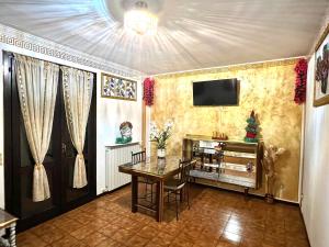 een eetkamer met een tafel en een tv aan de muur bij Al glicine in Lovere