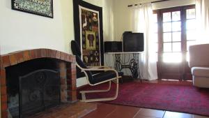 a living room with a fireplace and a tv at Chão da Lousa in Dornes