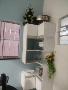 a kitchen with white cabinets and flowers on the wall at Casa dois quartos 5 pessoas, no centro de Belém in Belém