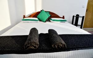 a bed with two pairs of shoes on it at Super View Home Stay in Ella
