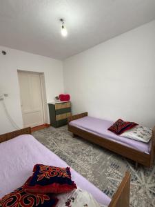 een slaapkamer met 2 bedden en een dressoir. bij Ali Guest House in Kara-Koo