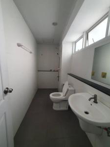 a bathroom with a toilet and a sink and a mirror at Royal Himalayan Hostel in Ban Phraek Sa