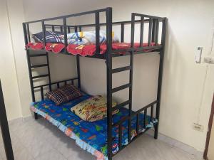 a black bunk bed with a bottom bed on it at Royal Himalayan Hostel in Ban Phraek Sa +2 photos