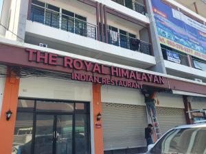 a building with a sign for the royal hindualamalam indian restaurant at Royal Himalayan Hostel in Ban Phraek Sa