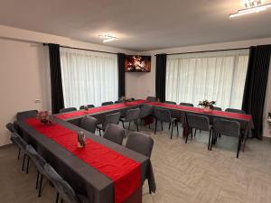 einen Konferenzraum mit Tischen und Stühlen mit rotem Tischtuch in der Unterkunft Pensiunea Dariana in Bucium-Sat