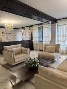een woonkamer met banken en een kroonluchter bij Hotel Pid Strihoju in Boekovel