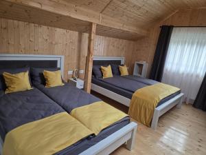 1 Schlafzimmer mit 2 Betten mit gelber und blauer Bettwäsche in der Unterkunft Pensiunea Dariana in Bucium-Sat + 5 Fotos