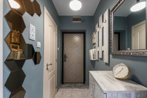 een hal met blauwe muren en een spiegel bij Dany's Apartments in Varna