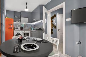 een kleine keuken met een zwarte tafel en stoelen bij Dany's Apartments in Varna +62 foto's