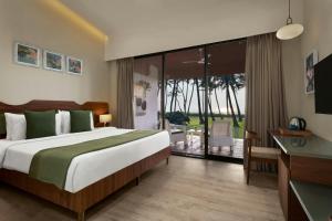 a bedroom with a large bed and a balcony at Blue Ocean The Fern Resort & Spa Ganpatipule, Series by Marriott in Ganpatipule +14 photos