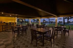 a restaurant with tables and chairs and a view of the ocean at Blue Ocean The Fern Resort & Spa Ganpatipule, Series by Marriott in Ganpatipule