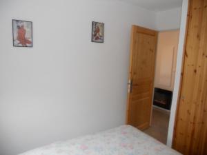 a bedroom with a bed and two pictures on the wall at les gentianes in La Salle Les Alpes