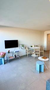 a living room with a flat screen tv and a table at Seanest - North Sea Stays in De Haan