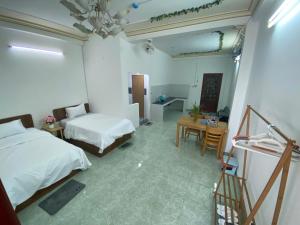 1 Schlafzimmer mit 2 Betten, einem Tisch und einem Schreibtisch in der Unterkunft Khách sạn K-Trang APARTMENT in Cần Thơ + 18 Fotos