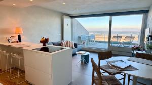 a kitchen and living room with a view of the ocean at Seanest - North Sea Stays in De Haan