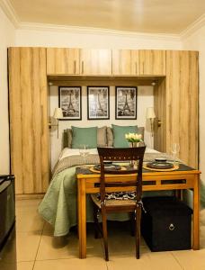 a bedroom with a bed and a table with a desk at Thorne's crip in Pretoria