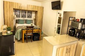 a room with a bed and a table and a kitchen at Thorne's crip in Pretoria