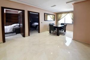 ein Esszimmer mit einem Tisch und ein Schlafzimmer in der Unterkunft Bellington Appart Hôtel in Saidia 