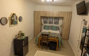 a small bedroom with a bed and a table at Thorne's crip in Pretoria