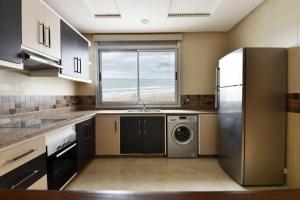 a kitchen with a stainless steel refrigerator and a dishwasher at Bellington Appart Hôtel in Saïdia